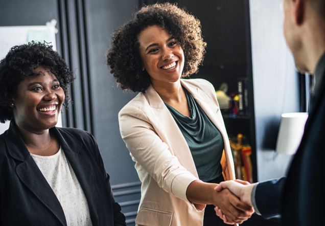 Photo of woman in professional attire shaking hands.